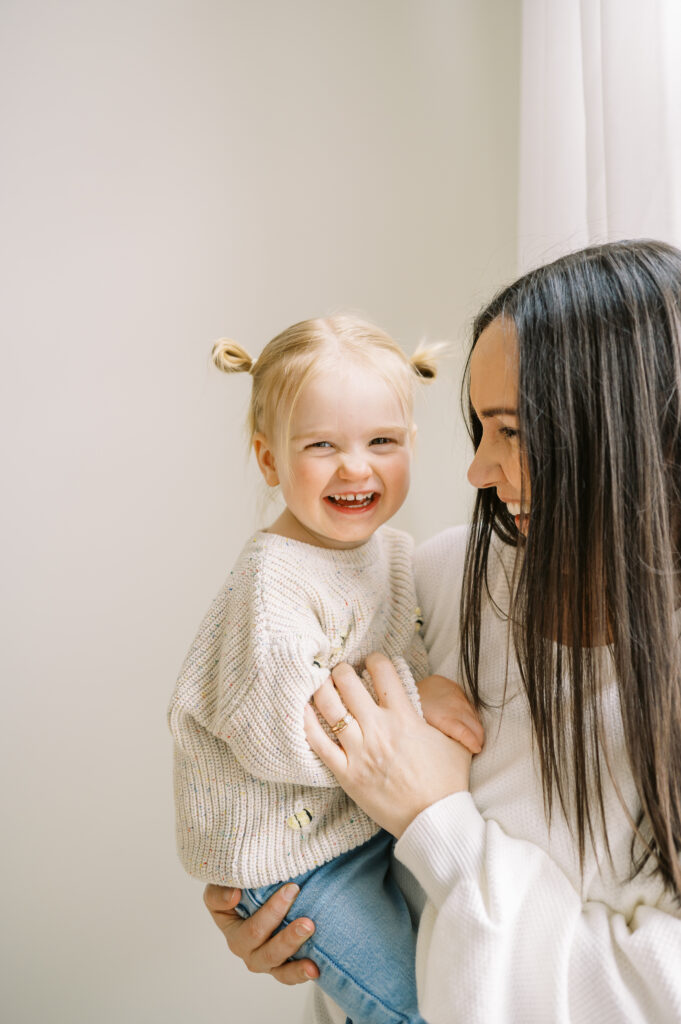 mom holding toddler and playing during family photo shoot in Columbus Ohio